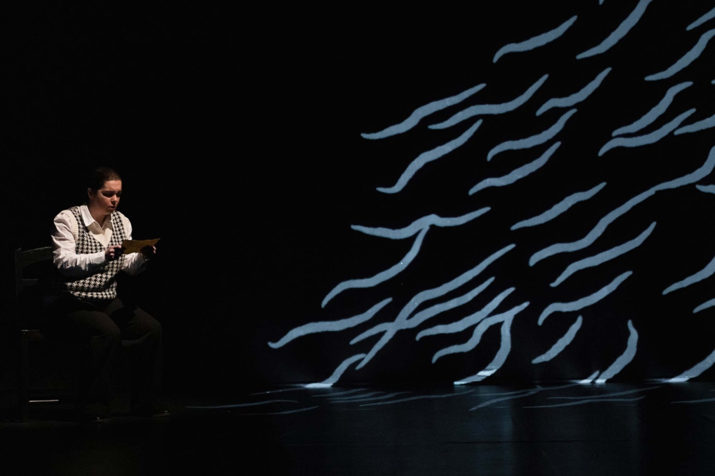 Pilar Murube – La noche que no llega Pilar Murube in einer Bühnenszene aus „La noche que no llega“ mit abstrakten Lichtprojektionen.