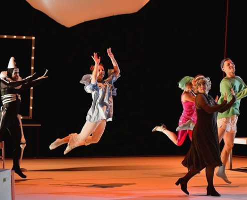 Szene aus der Tanzpantomime „Zaubernacht“ von Kurt Weill mit mehreren Darstellerinnen und Darstellern auf der Bühne.